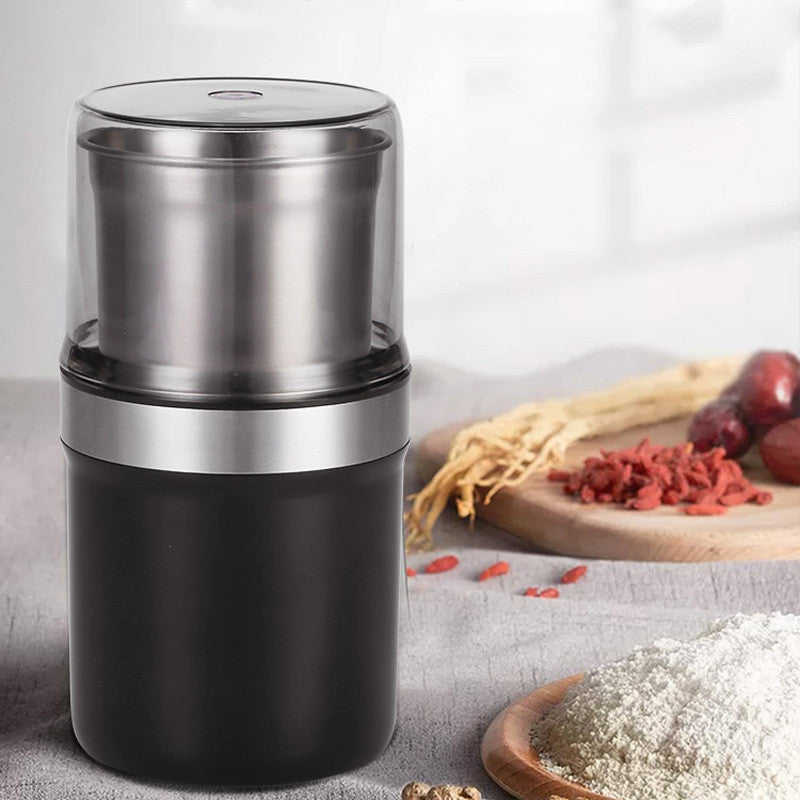 Black and silver spice grinder on a surface with ingredients in the background