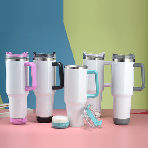 Set of white tumblers with colorful handles and lids on a pink surface with a blue and green background.