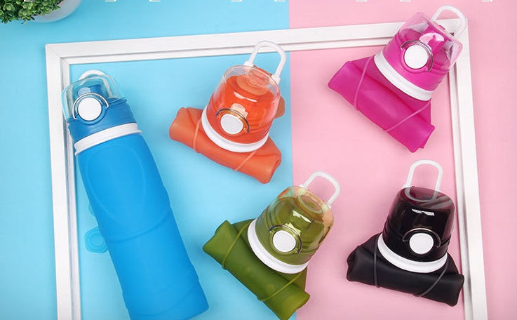 Set of colorful folding water bottles on a pink and blue background