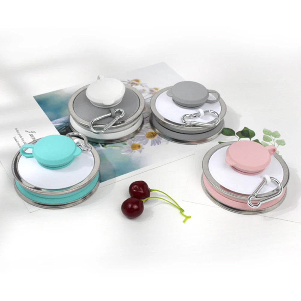 Set of small round containers with colorful lids on a white surface.