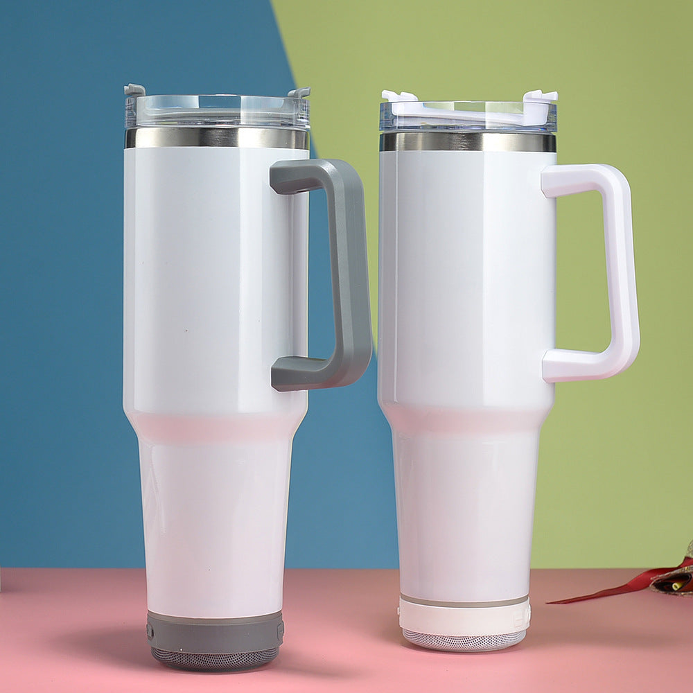 Two insulated travel mugs with handles on a pink surface with a colorful background