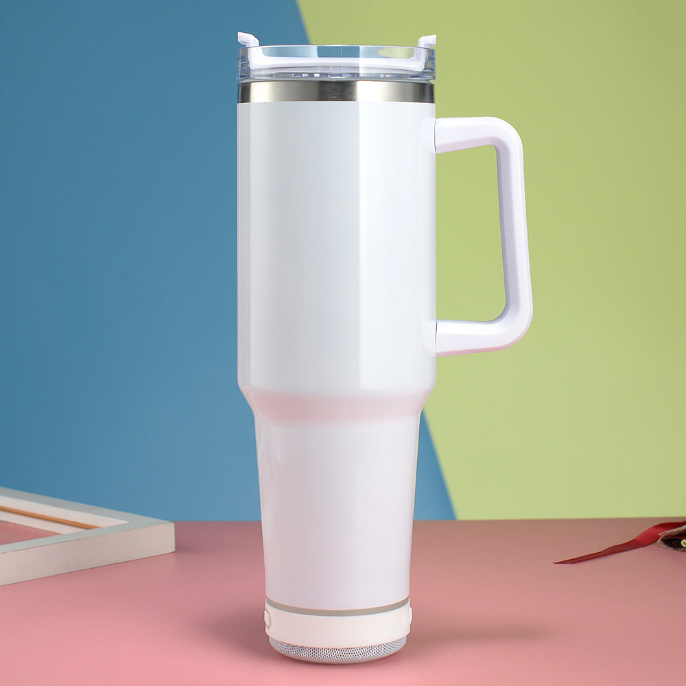 White insulated mug with handle on a pink surface against a colorful background