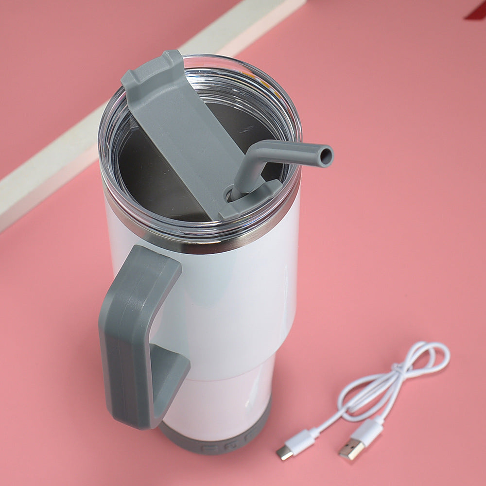 White travel mug with gray handle and lid, USB cable on pink background