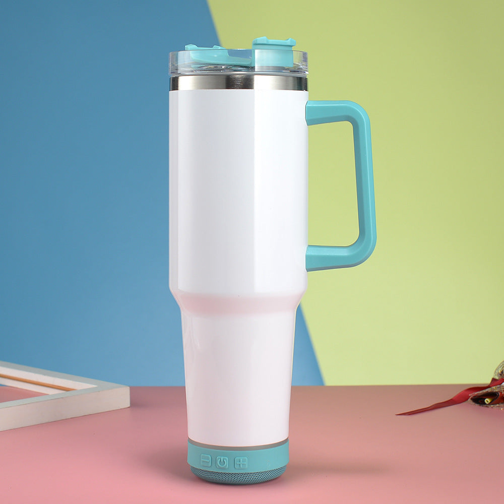 White tumbler with blue handle and accents on a pink surface with a colorful background