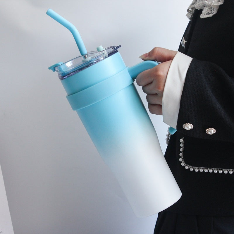 Person holding a gradient blue and white tumbler with a straw on a light gray background