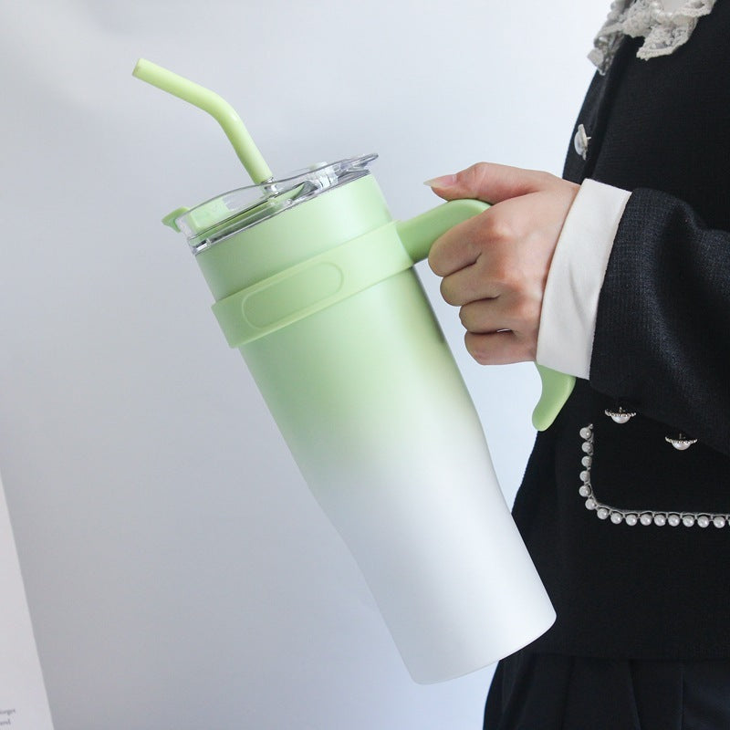Person holding a gradient green to white tumbler with a straw on a light gray background