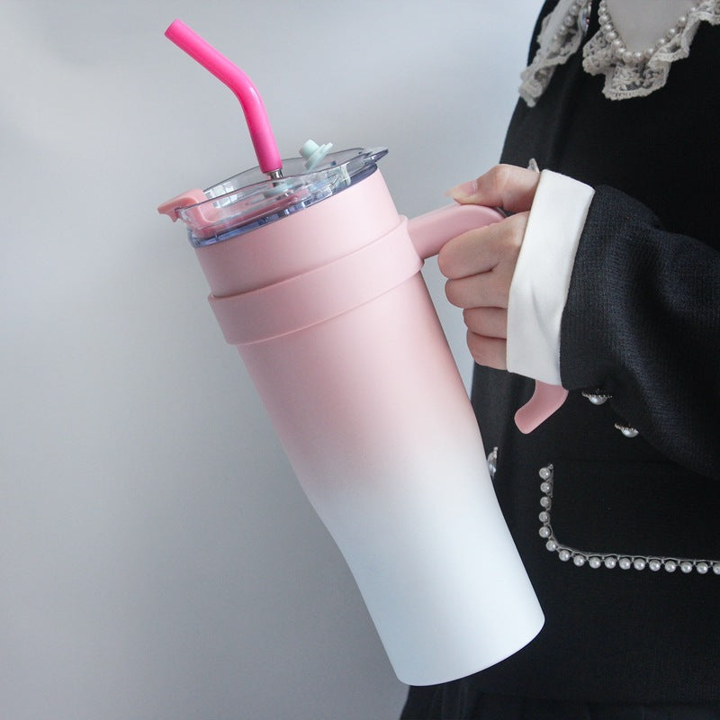 Person holding a pink and white tumbler with a straw against a plain background