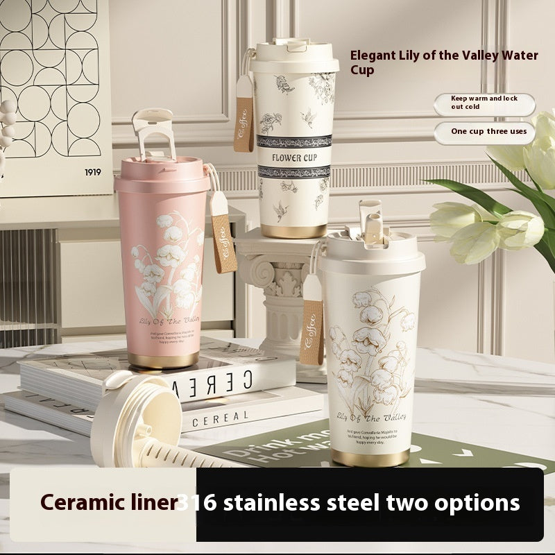 Ceramic and stainless steel cups with floral designs on a table.