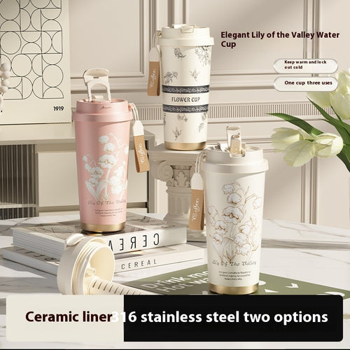 Ceramic and stainless steel cups with floral designs on a table.