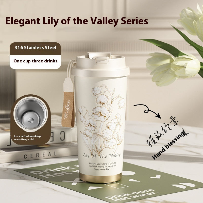 Elegant Lily of the Valley Series stainless steel tumbler with floral design on a table.