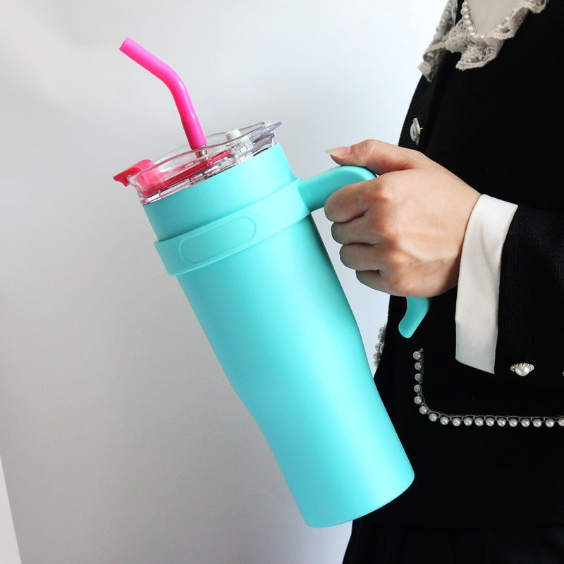 Person holding a turquoise tumbler with a pink straw against a light gray background